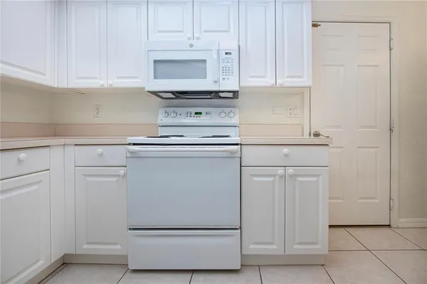 a kitchen with white cabinets and white appliances