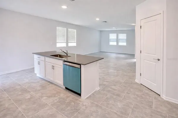 a kitchen with granite countertop a sink and cabinets
