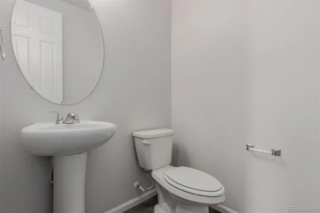a bathroom with a toilet a sink and mirror