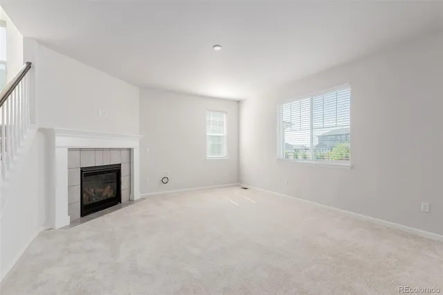 an empty room with windows and fireplace