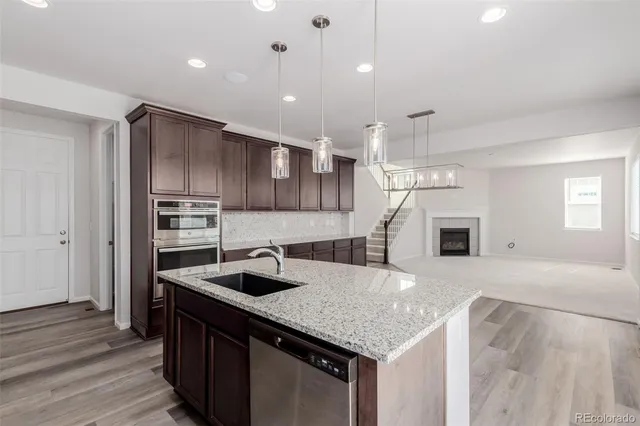a kitchen with kitchen island granite countertop a sink and refrigerator