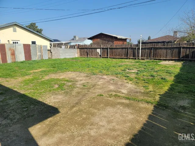 a view of a house with a big yard and large trees