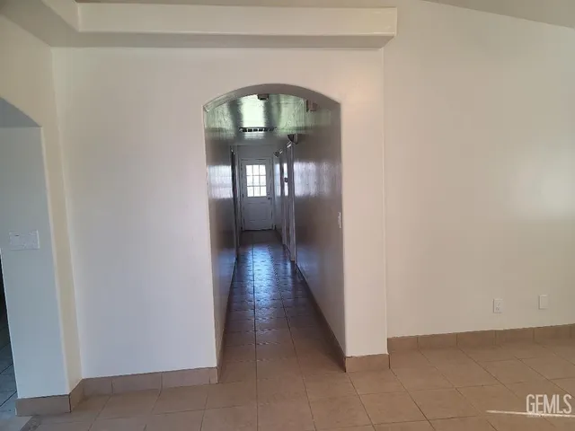 a view of a hallway with wooden floor and a living room