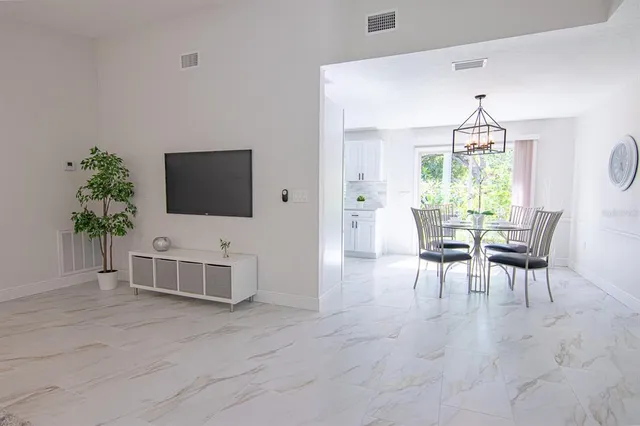 a living room with furniture a chandelier and a flat screen tv