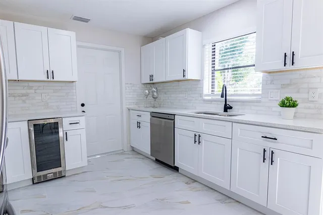 a kitchen with white cabinets and white appliances
