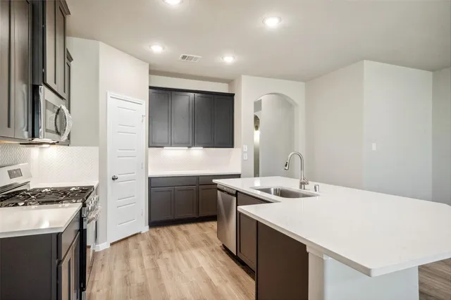 a kitchen with a sink stove and refrigerator