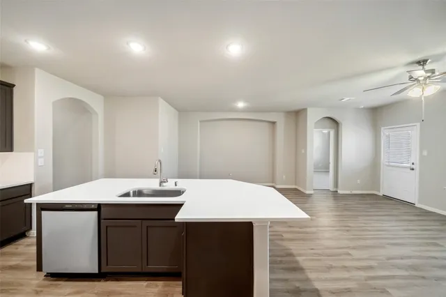 a kitchen with a sink cabinets and wooden floor