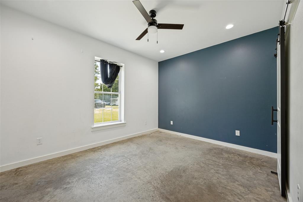 822 Private Road 7370 Point, TX 75472 - Photo 29 of 30 Interior room featuring a bold accent wall, concrete flooring, a ceiling fan, recessed lighting, and a single window