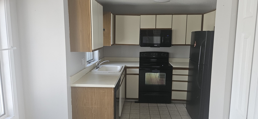 700 Shore Drive, Unit 513 Fall River, MA 02721 - Photo 8 of 12 a kitchen with a refrigerator and a stove