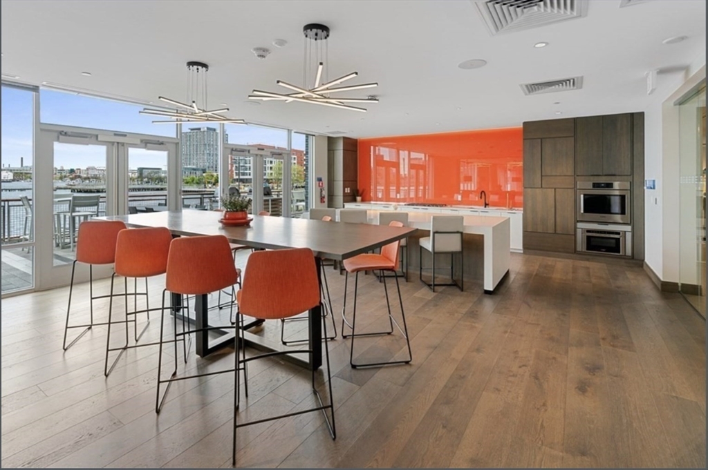 45 Lewis Street, Unit 312 Boston, MA 02128 - Photo 15 of 17 a large dining hall with stainless steel appliances granite countertop a table chairs and a view of living room