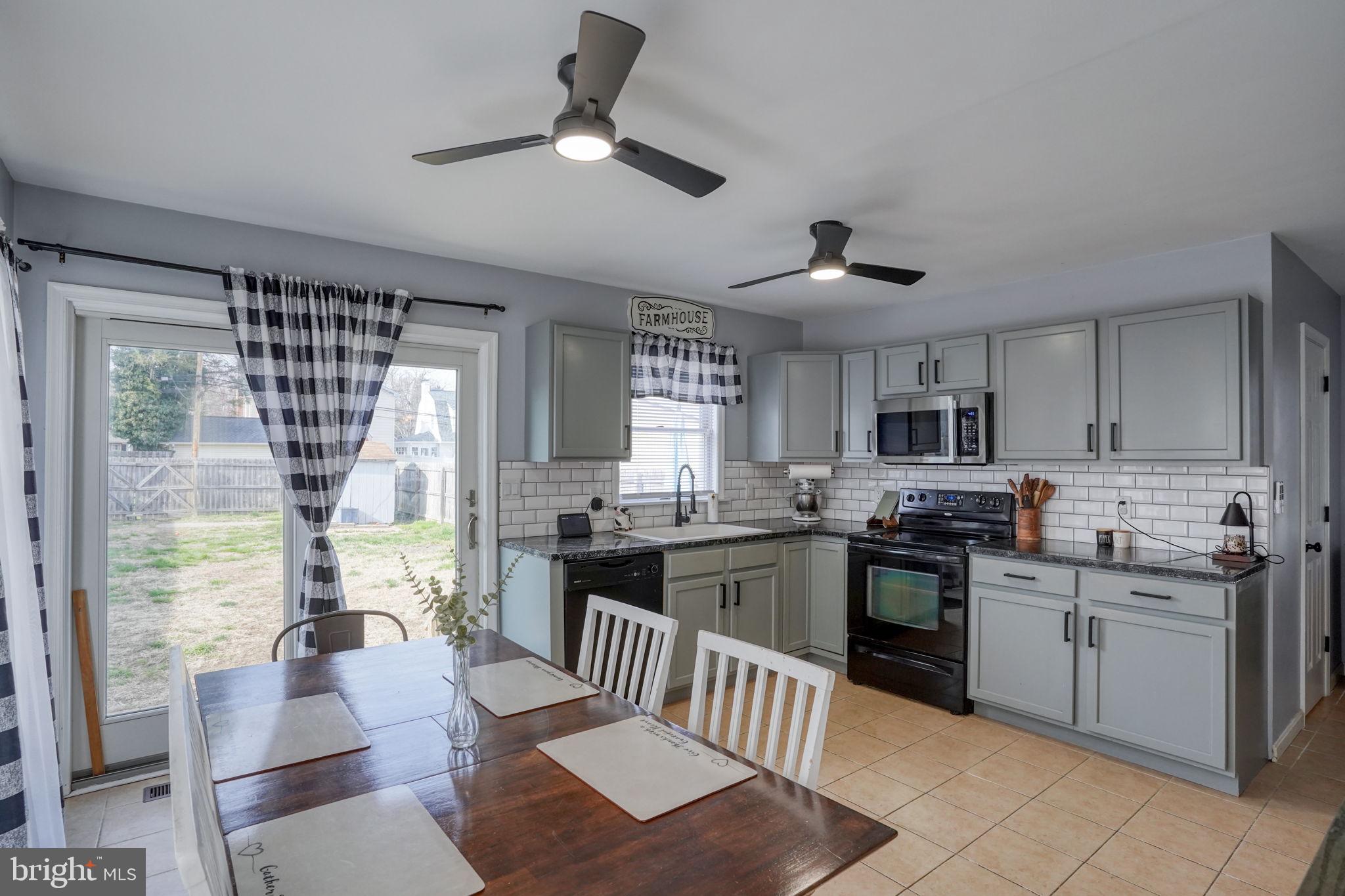 31 Washington Street Dover, DE 19901 - Photo 22 of 38 a kitchen with stainless steel appliances granite countertop a stove top oven a sink dishwasher a dining table and chairs with wooden floor