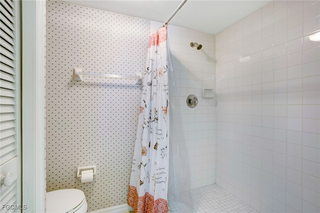 13256 Whitehaven Lane, Unit 501 Fort Myers, FL 33966 - Photo 20 of 28 a bathroom with a shower curtain