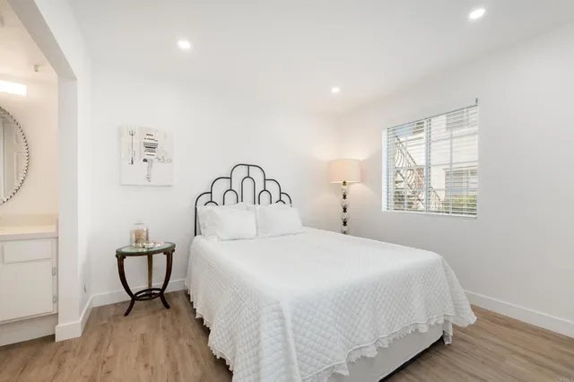 a view of a hallway with wooden floor and a bathroom