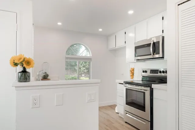 a kitchen with stainless steel appliances a stove microwave and white cabinets