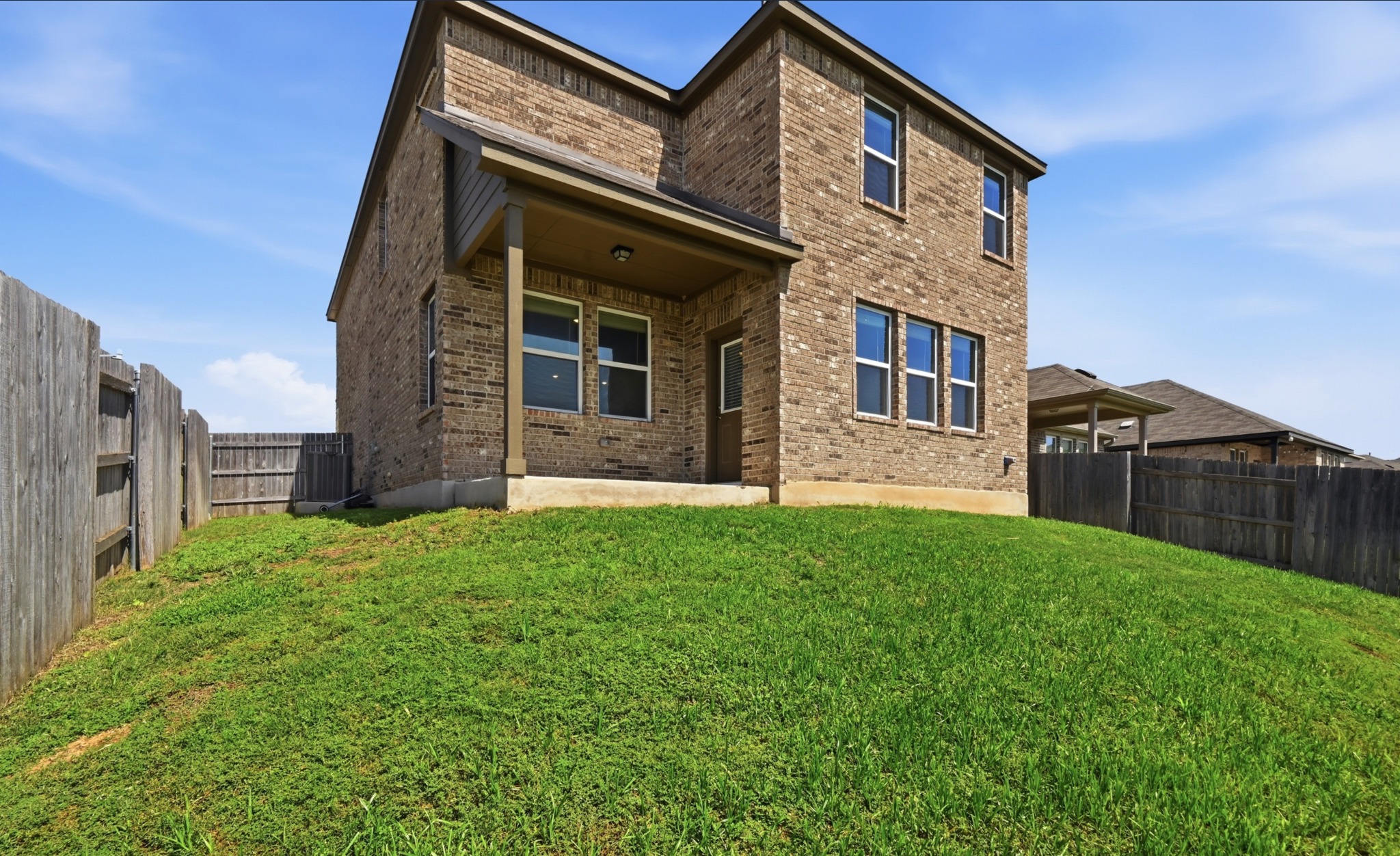 488 Pepperbark Loop Buda, TX 78610 - Photo 31 of 31 A well-maintained fenced yard offers privacy and a brick exterior house.