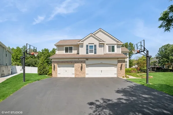 a view of a house with a yard and large tree