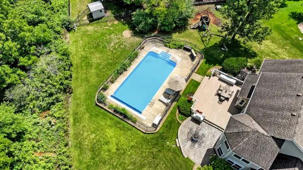 an aerial view of a house with a swimming pool and garden