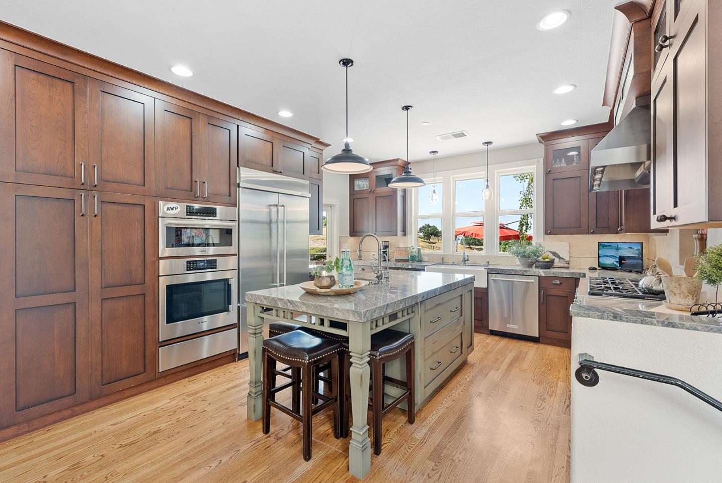 4460 Roop Road Gilroy, CA 95020 - Photo 13 of 68 a kitchen with stainless steel appliances granite countertop a stove top oven a sink dishwasher a dining table and chairs with wooden floor