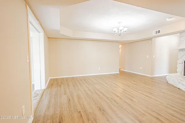 a view of a hallway with wooden floor and closet area