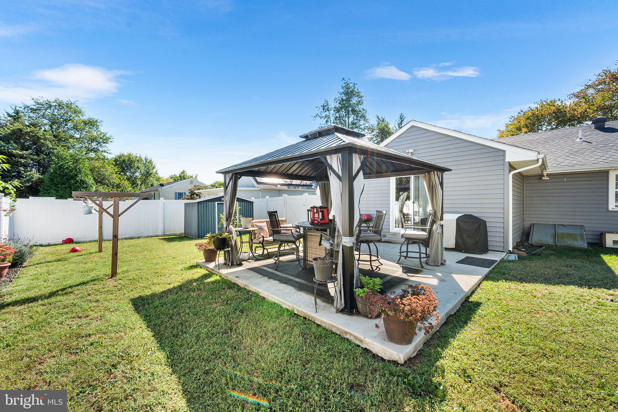 128 Michigan Road Pennsville, NJ 08070 - Photo 25 of 30 a view of a backyard with table and chairs under an umbrella