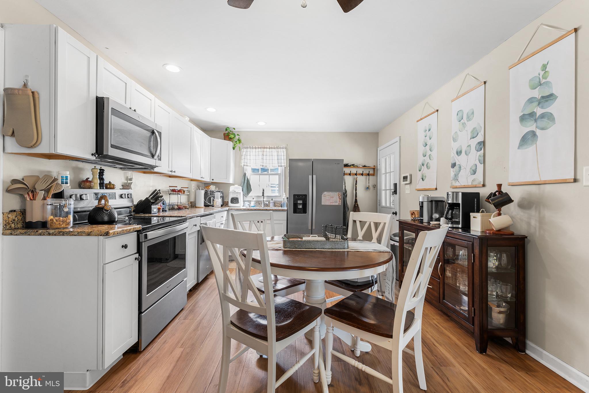 128 Michigan Road Pennsville, NJ 08070 - Photo 8 of 30 a kitchen with stainless steel appliances kitchen island granite countertop a dining table chairs and a refrigerator