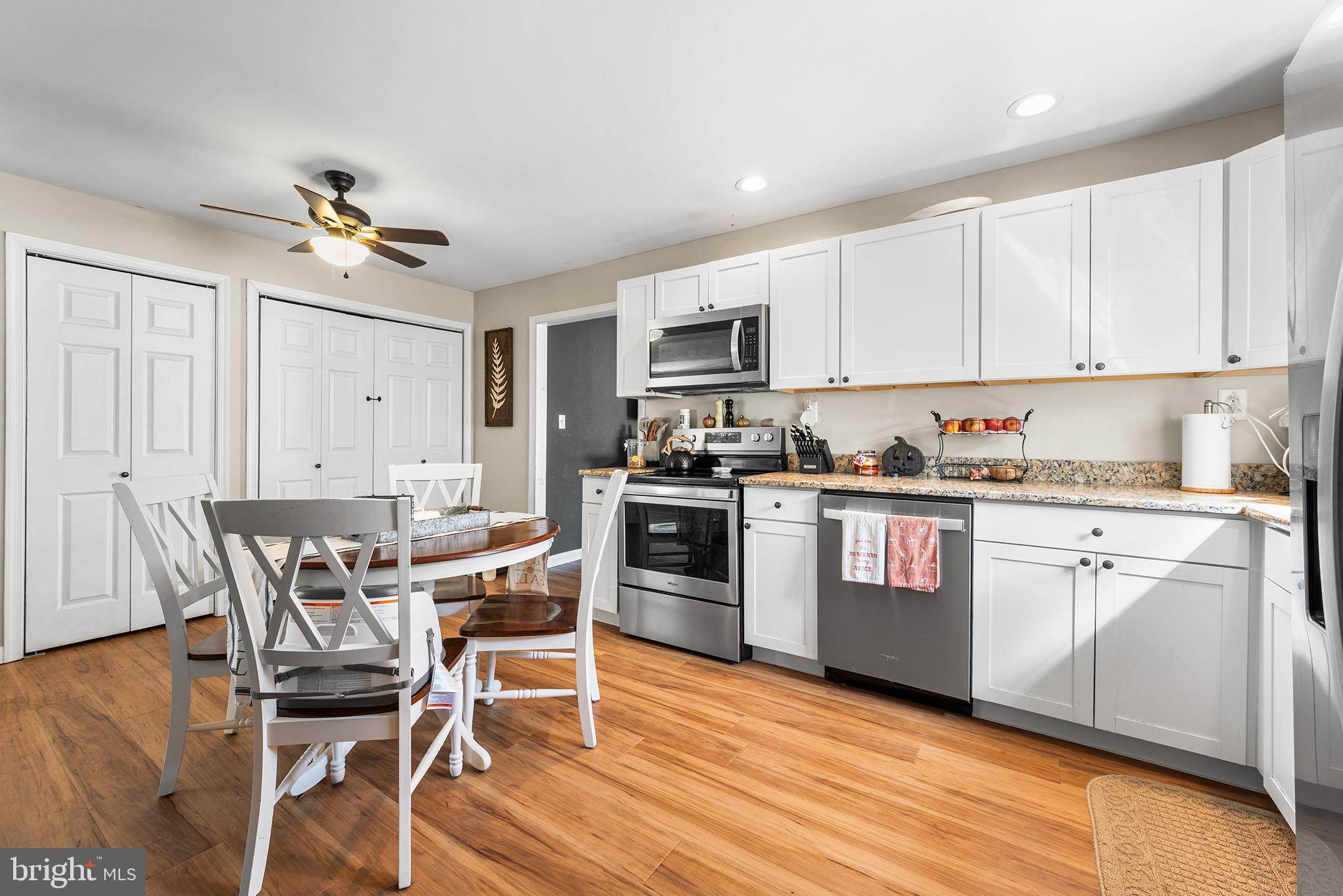 128 Michigan Road Pennsville, NJ 08070 - Photo 9 of 30 a kitchen with a table chairs a sink dishwasher stove and cabinets with wooden floor