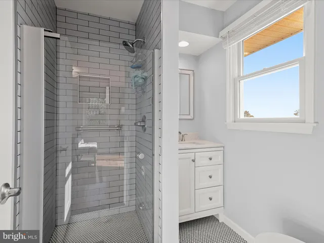 a bathroom with a granite countertop sink toilet and a mirror
