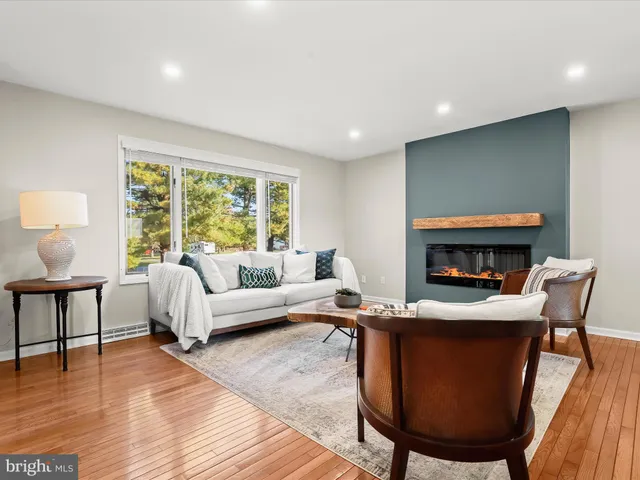 a living room with furniture a large window and a fireplace