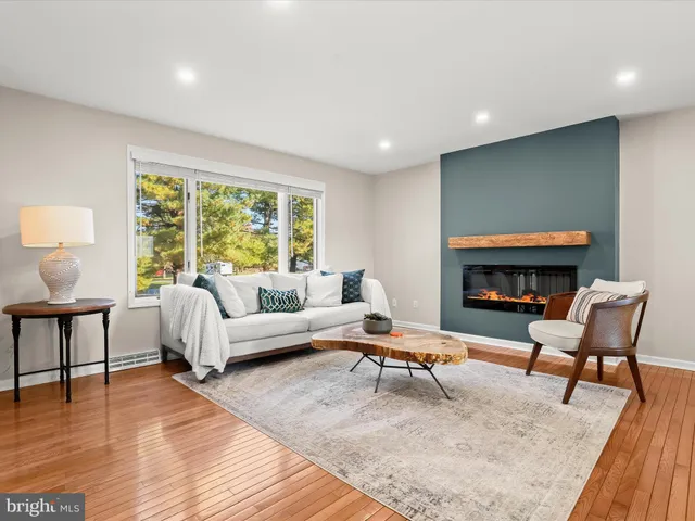 a living room with furniture a large window and a fireplace