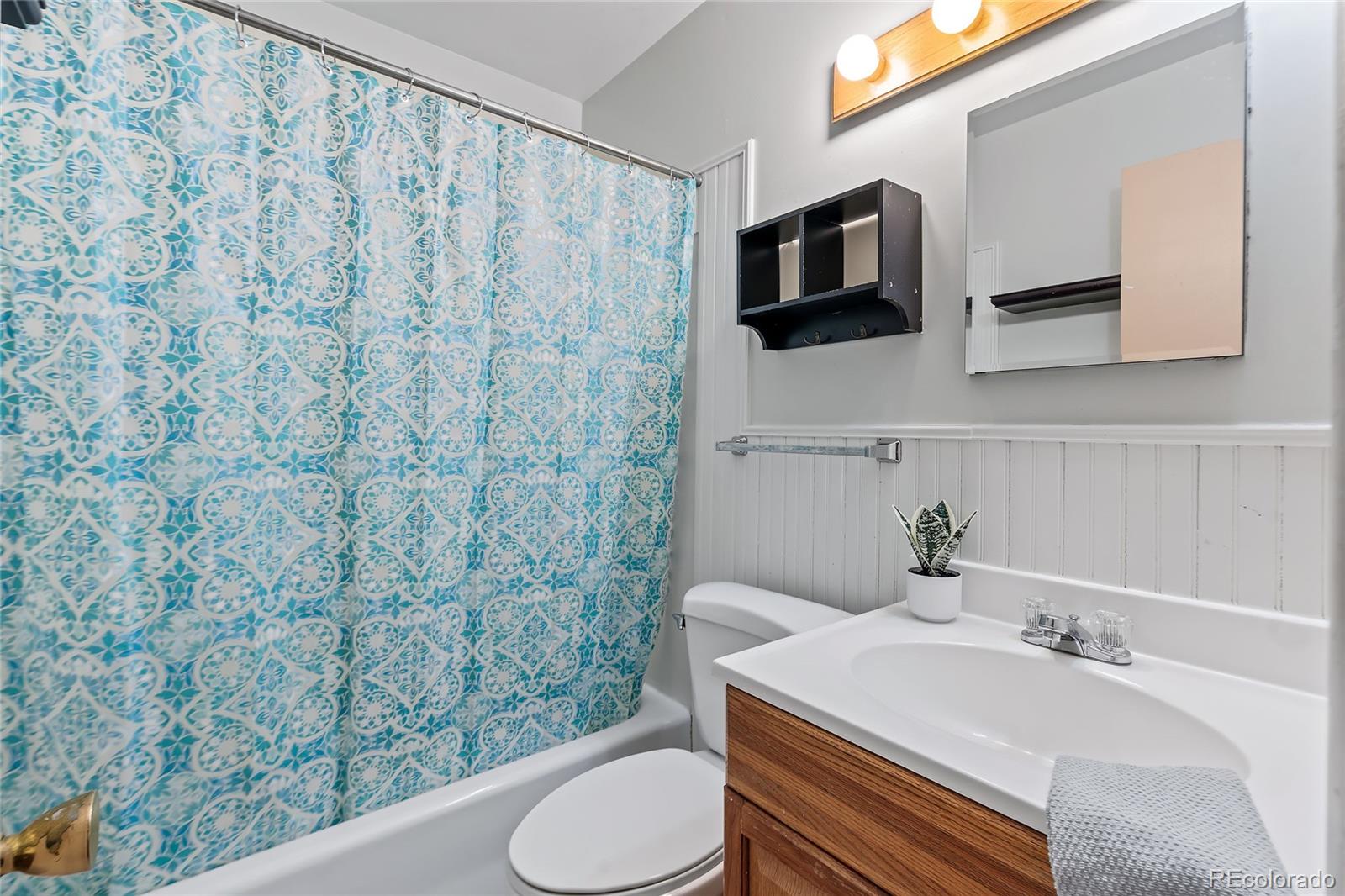 1971 Evergreen Avenue Boulder, CO 80304 - Photo 25 of 36 a bathroom with a sink toilet a mirror and shower curtain
