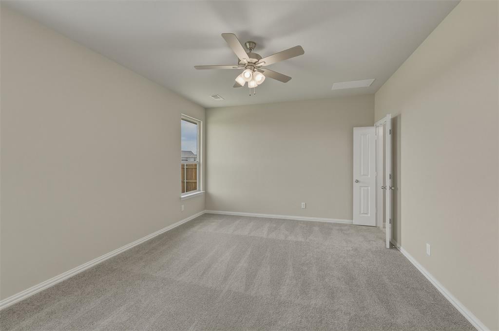 1209 Colca Drive Springtown, TX 76082 - Photo 12 of 24 Carpeted room featuring a ceiling fan with integrated lighting, a single window, and a white paneled door
