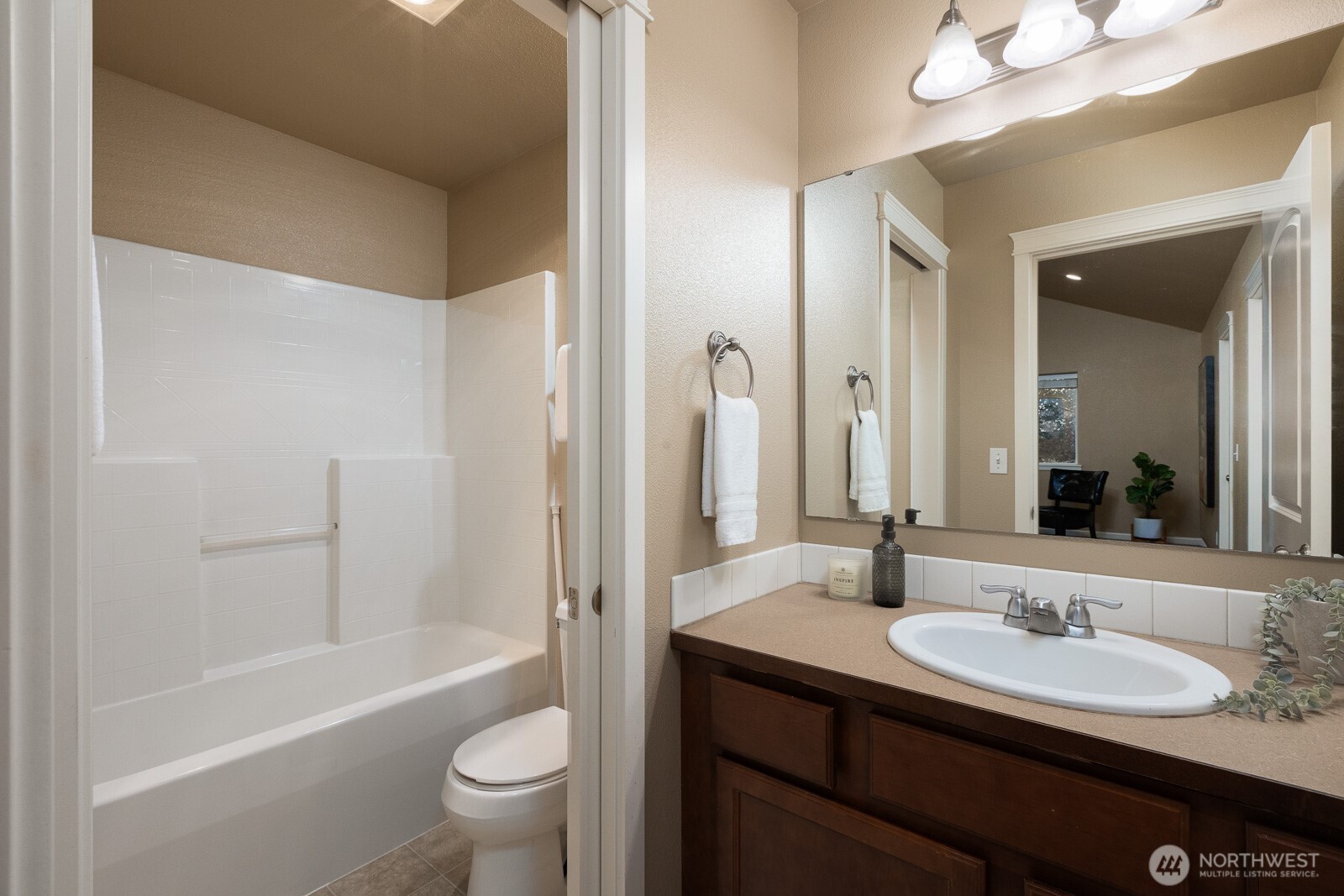 5002 70th Way Southeast Lacey, WA 98513 - Photo 28 of 40 a bathroom with a sink a toilet and a large mirror