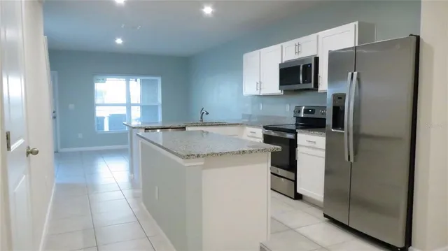 a kitchen with a refrigerator and a sink