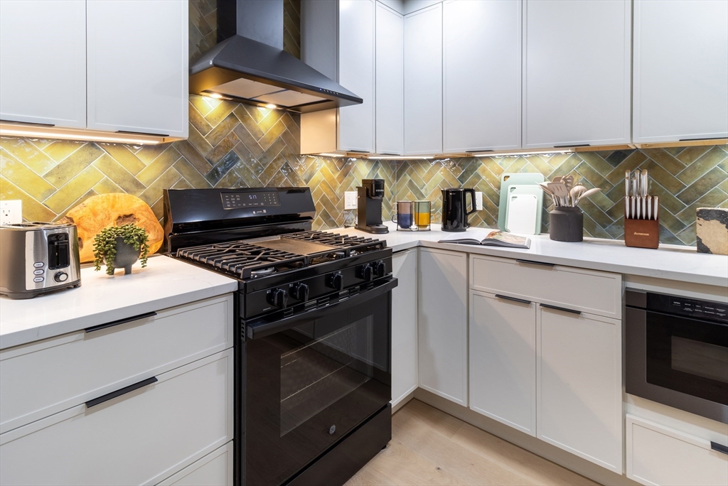 4 Snelling Place, Unit 4 Boston, MA 02113 - Photo 6 of 15 a kitchen with a sink stove and cabinets