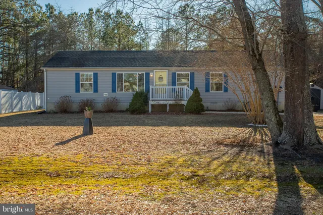 a view of a house with backyard and furniture