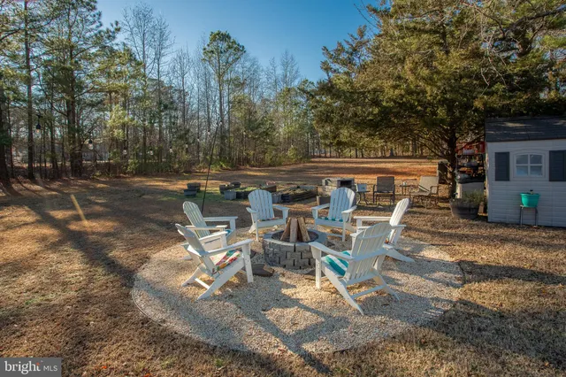 a kitchen with stainless steel appliances kitchen island granite countertop a stove a sink a dining table and chairs with wooden floor