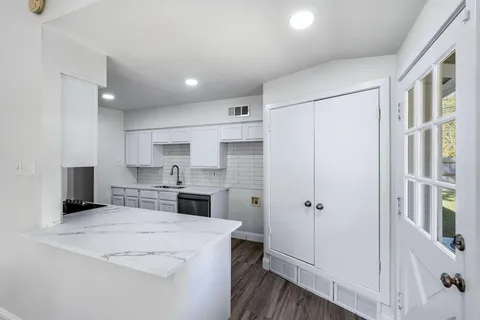 a kitchen with a refrigerator a sink and cabinets