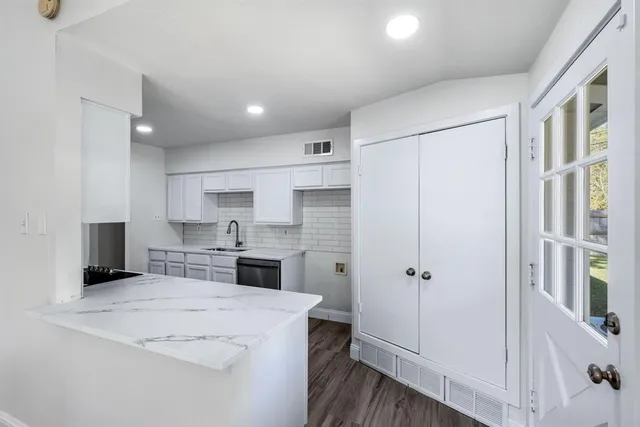 a kitchen with a refrigerator a sink and cabinets
