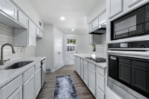 a kitchen with stainless steel appliances granite countertop a sink and stove top oven
