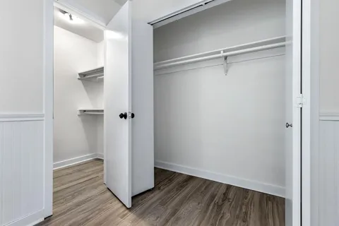 a view of closet area with wooden floor
