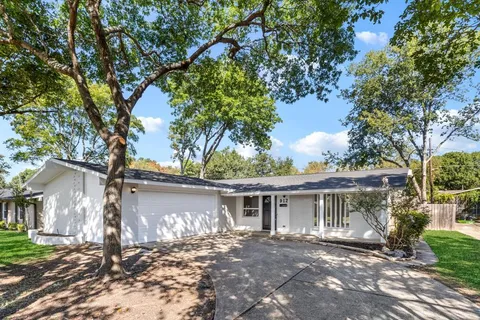 a front view of a house with a yard and potted plants
