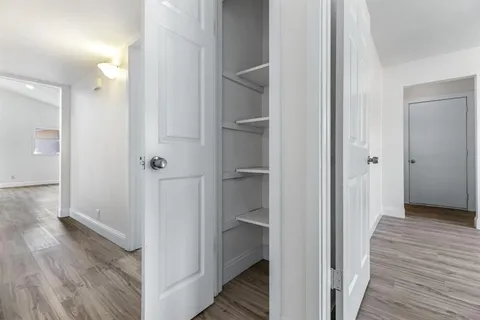 a view of a hallway with wooden floor