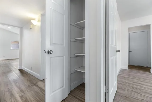 a view of a hallway with wooden floor