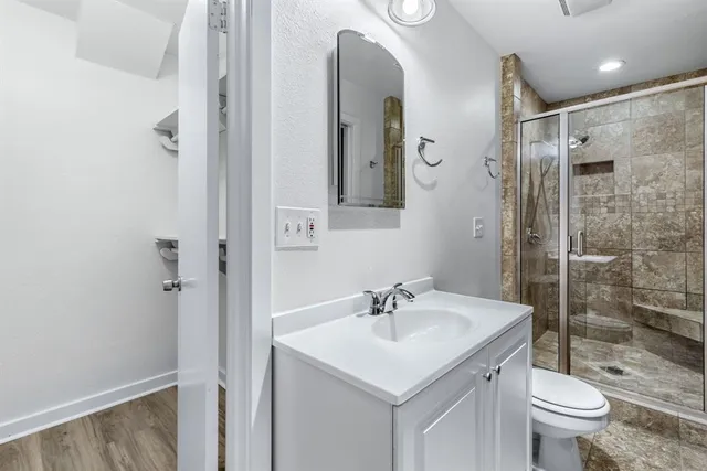 a bathroom with a shower sink vanity mirror and toilet