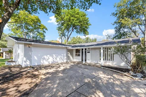 a front view of a house with a yard and potted plants