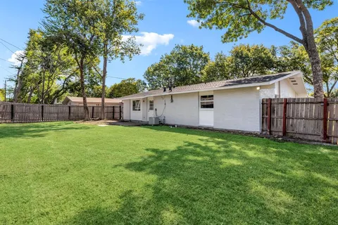 a view of a yard with a wooden fence