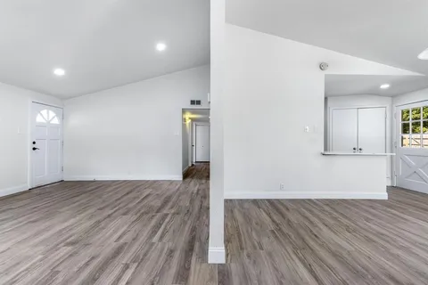 a view of empty room with wooden floor