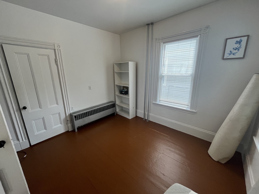 32 Howell Street, Unit 2 Boston, MA 02125 - Photo 11 of 24 an empty room with wooden floor and windows