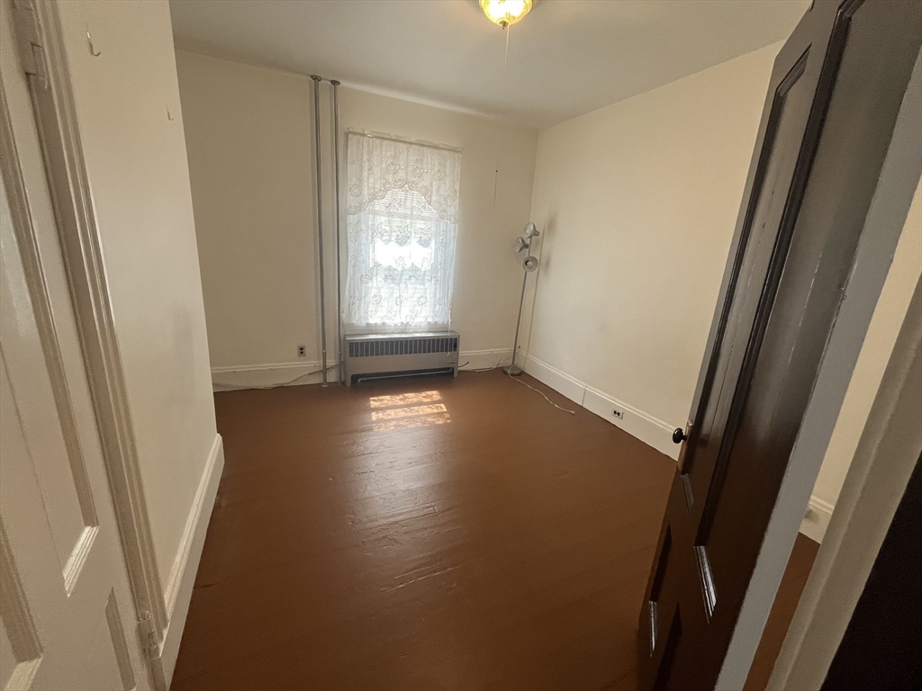 32 Howell Street, Unit 2 Boston, MA 02125 - Photo 20 of 24 an empty room with wooden floor and windows