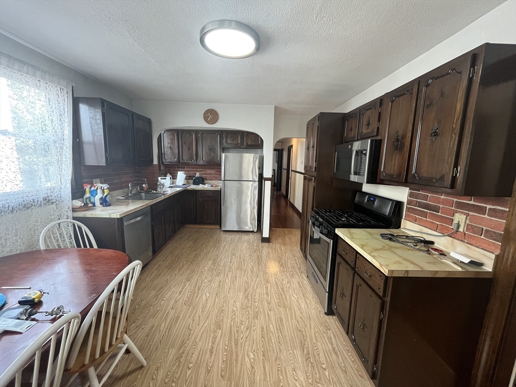 32 Howell Street, Unit 2 Boston, MA 02125 - Photo 3 of 24 a kitchen with stainless steel appliances granite countertop a sink stove and refrigerator